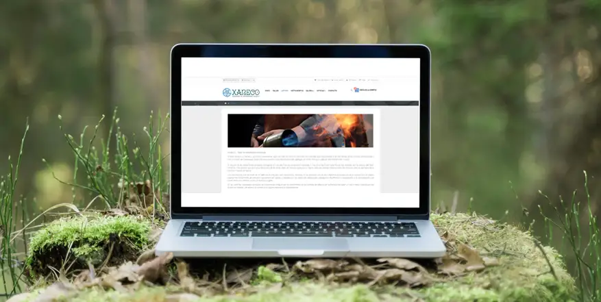 Foto de portatil encendido mostrando la web de Xaneco